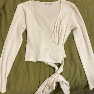 White cross shirt with tie at bottom.